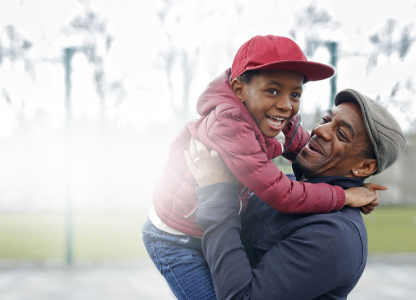 father and son playing in park